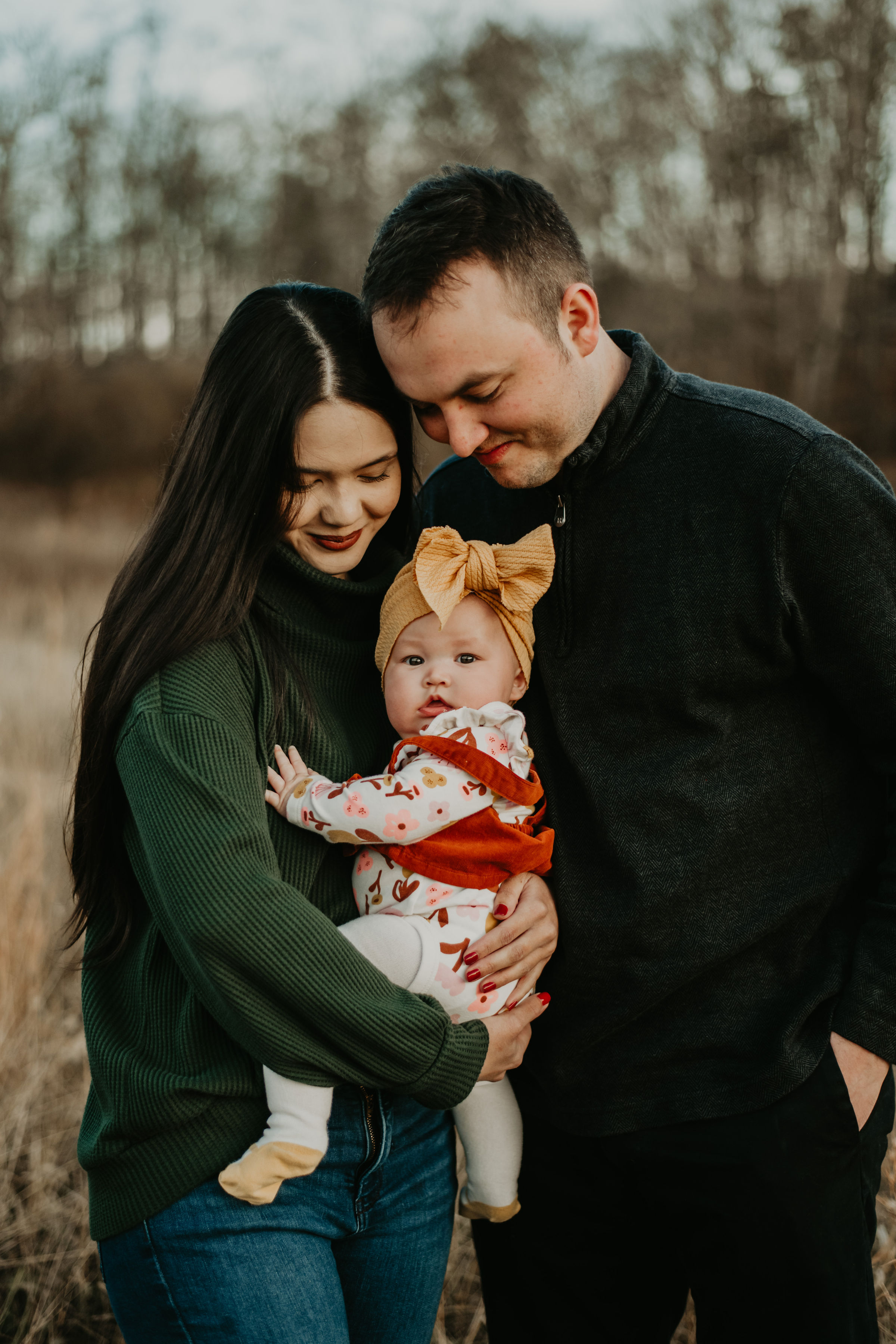 Parents cuddling their baby during a fall family session
